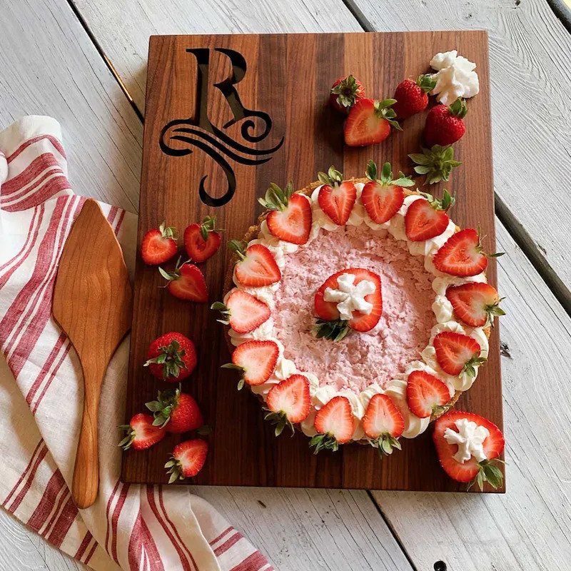 overhead: single initial monogram cutting board with strawberry cake