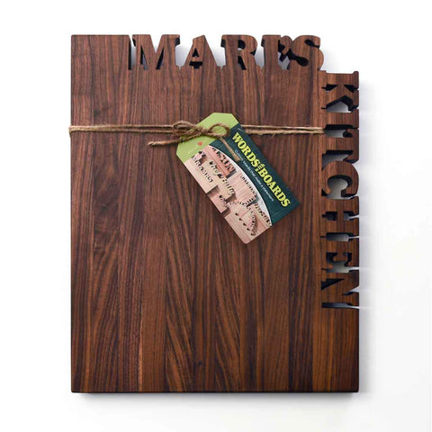 Walnut vertical cutting board with name Mari's cutout on top and the word Kitchen cutout on right side